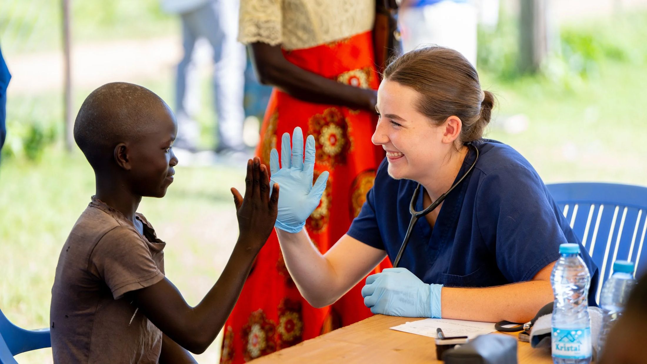 A nurse high-fiving a child at a clinic