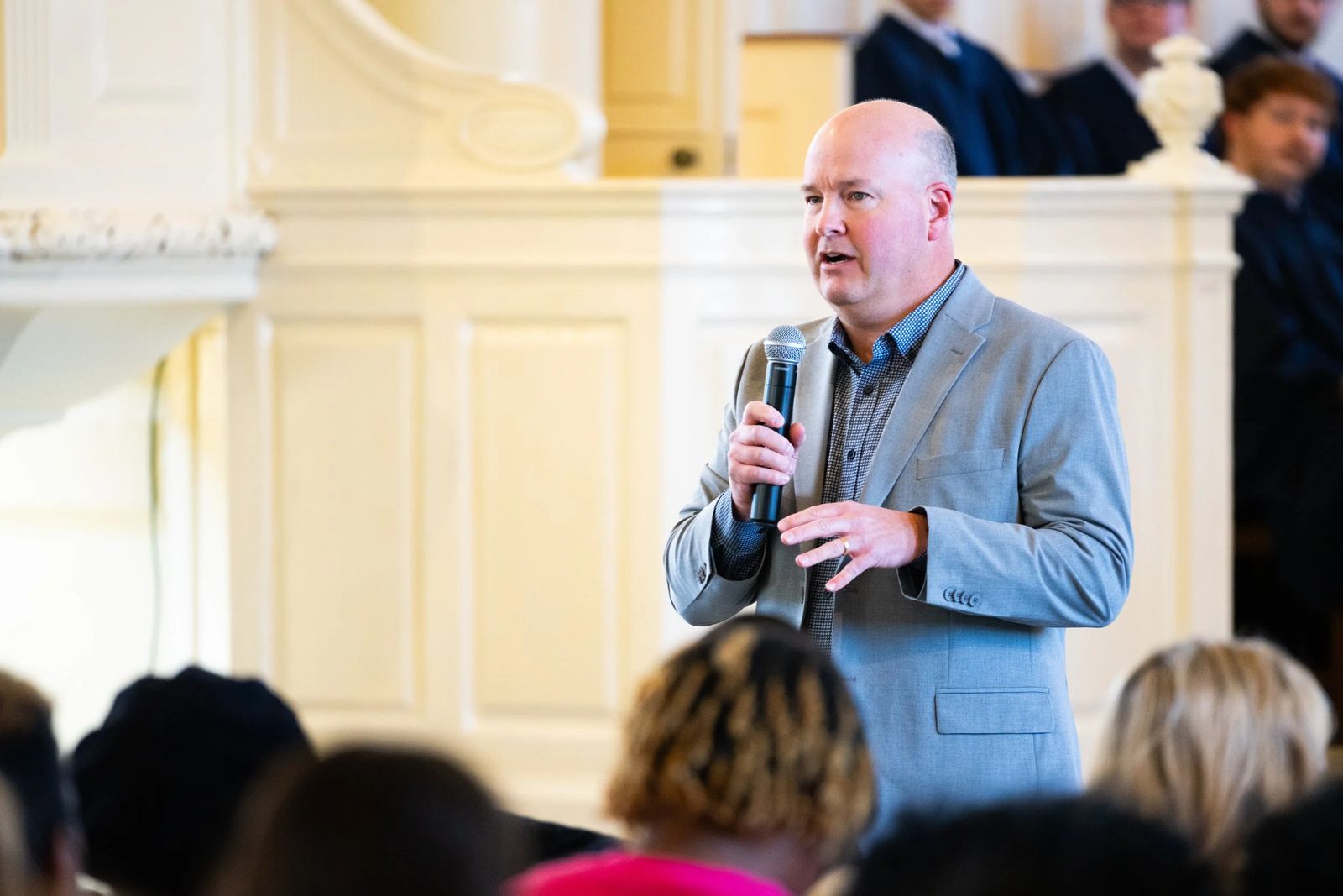 A speaker addressing a full room at a corporate event