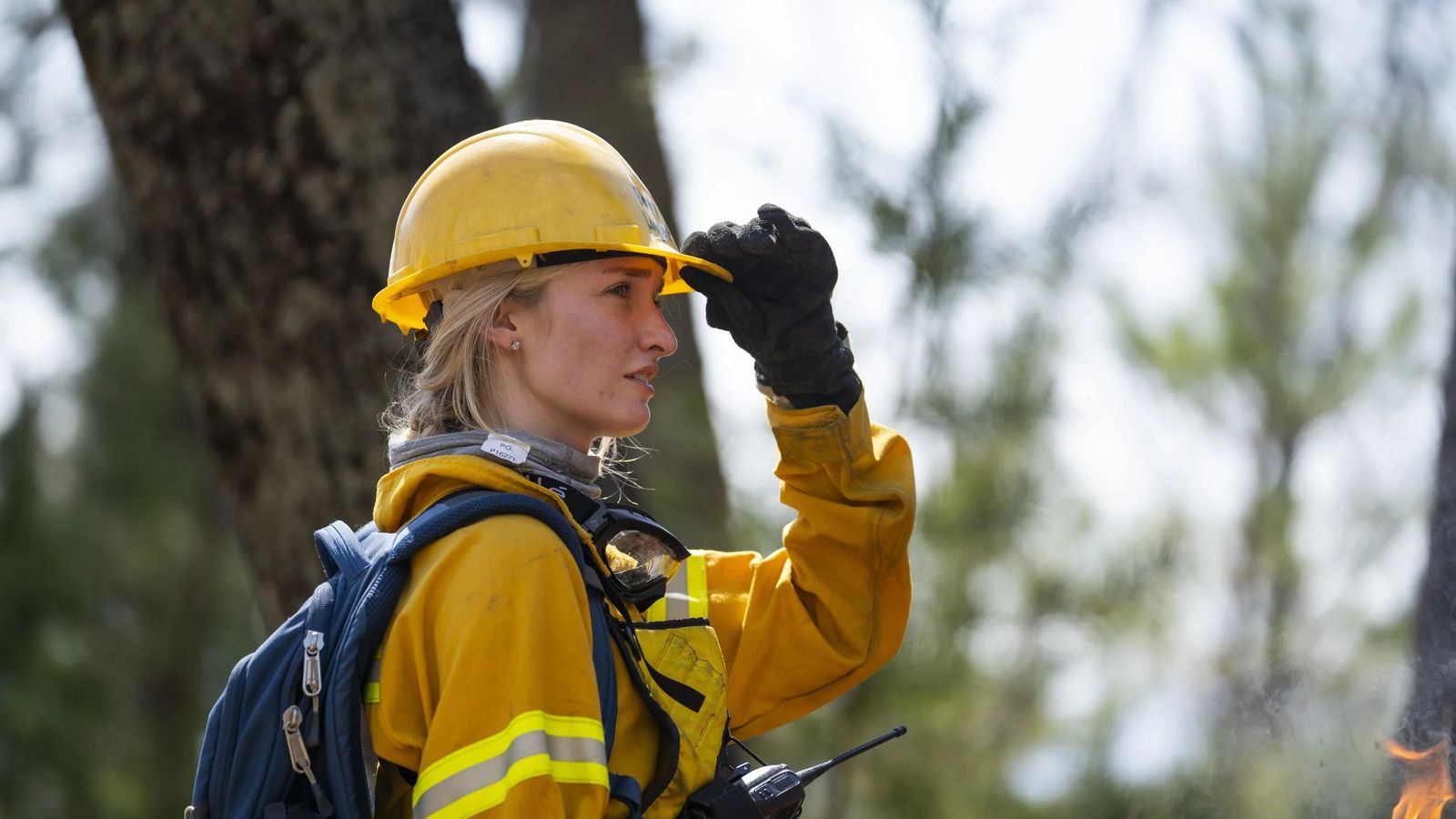 A wildland firefighter in protective gear during a prescribed burn