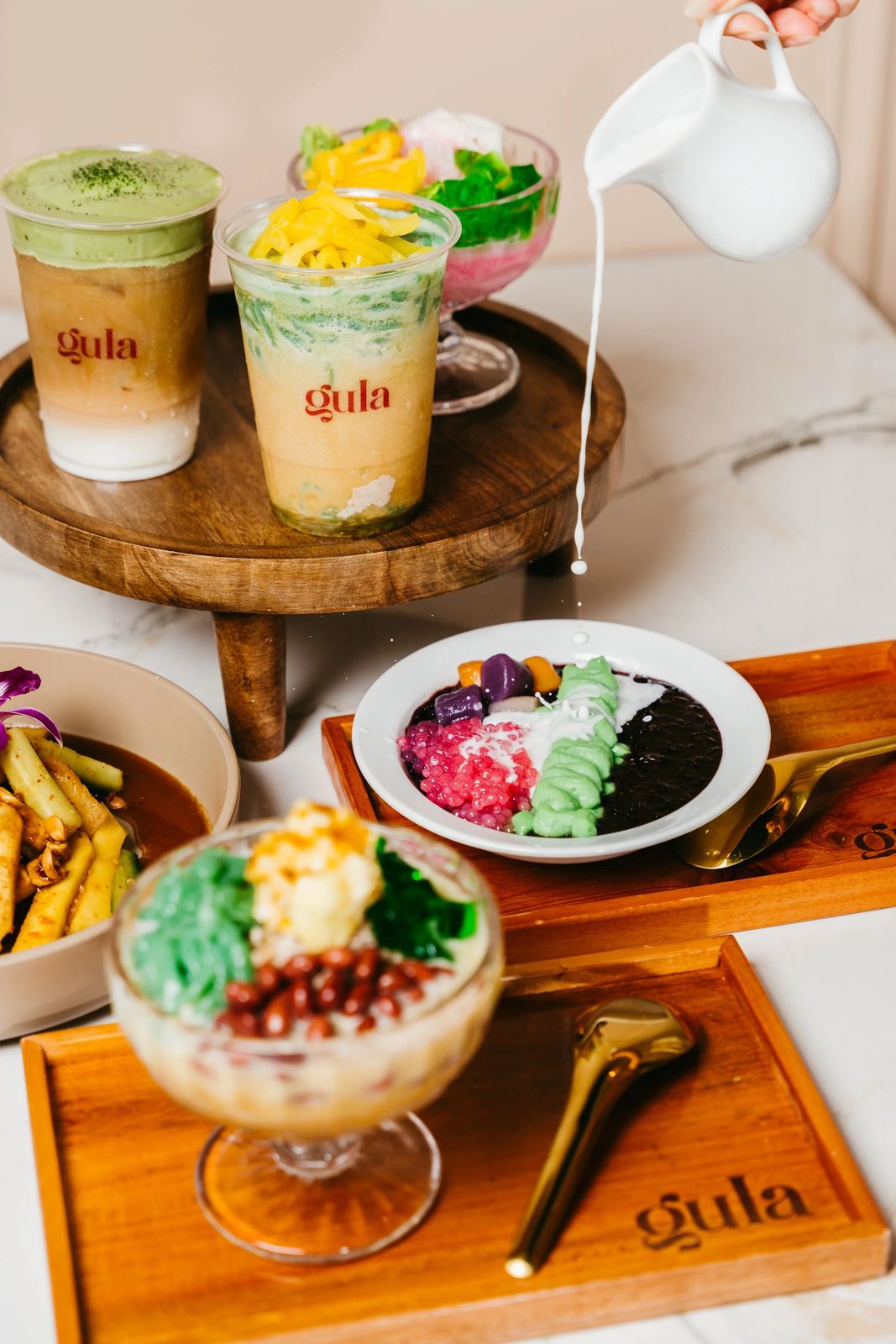 Gula’s signature desserts and drinks styled on a marble table